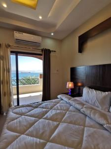 a bedroom with a large bed with a large window at Nice View Hotel فندق الأطلالة الجميلة للعائلات فقط in Aqaba