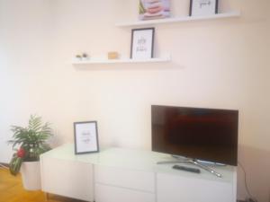 una sala de estar con TV en un armario blanco en Apartamento CONFORT BEACH, 300 mtr playa, en Gijón
