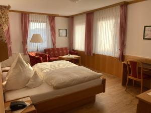 ein Hotelzimmer mit einem Bett und einem Stuhl in der Unterkunft Bengel's Hotel zur Krone in Mülheim-Kärlich