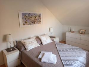 een slaapkamer met een bed met 2 nachtkastjes en 2 lampen bij Cosy Loft in Helsinki