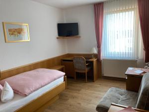 Habitación de hotel con cama, escritorio y TV. en Bengel's Hotel zur Krone, en Mülheim-Kärlich