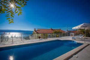 a swimming pool in front of a house at Apartments Saga 2 - with pool in Lokva Rogoznica