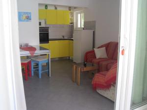 una pequeña cocina con sofá rojo y mesa en Apartment Gana - 50m from the sea en Maslinica