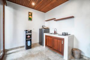 a kitchen with a sink and a refrigerator at Gigimas Private Villa in Ubud