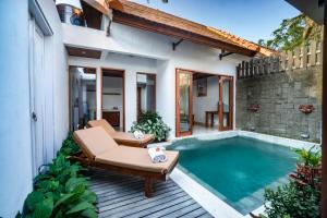 a patio with a swimming pool next to a house at Gigimas Private Villa in Ubud
