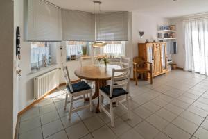 a dining room with a table and chairs at Ferienhaus Strandläufer in Neßmersiel +11 photos