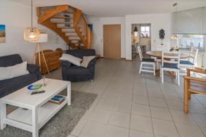 a living room with a couch and a table at Ferienhaus Strandläufer in Neßmersiel