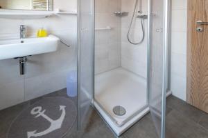 a bathroom with a shower and a sink at Ferienhaus Strandläufer in Neßmersiel