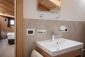 a bathroom with a sink and a mirror at Ciasa Willy App Conturines in La Villa