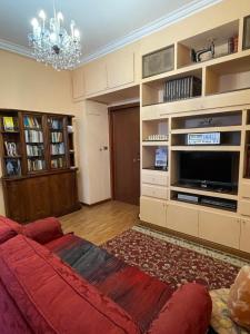 een woonkamer met een bank en een televisie bij [Duomo walking distance] elegant flat with view in Milaan