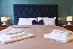 Una cama con toallas encima y dos lámparas. en Acropolis of Athens from Ermou str, en Atenas