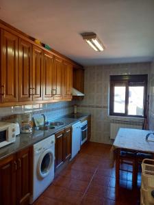 a kitchen with a sink and a washing machine at Casa Rural La Cerra in Navalguijo