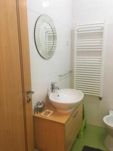 une salle de bains avec un lavabo et un miroir dans l'établissement Apartamento Mar com Parking, à Nazaré 14 autres photos