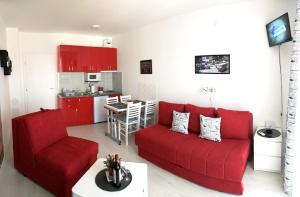 a living room with a red couch and a kitchen at Studio La Casa in Soko Banja