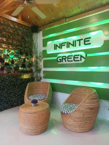 two wicker stools in front of a green wall at Infinite Green Pension in Puerto Princesa City