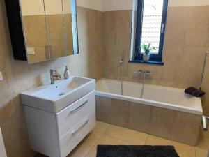 a bathroom with a sink and a tub and a mirror at Ferienhaus Sternschnuppe in Freyung