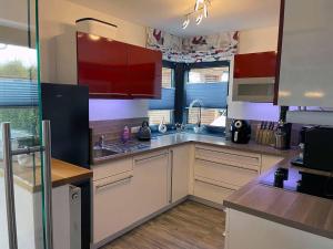 a kitchen with white counters and red cabinets at Ferienhaus Sternschnuppe in Freyung