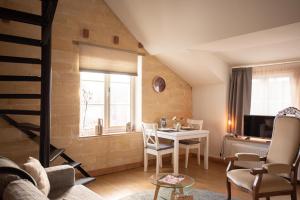 a living room with a table and chairs and a tv at Jeanneke Bosch in Schin op Geul