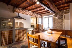a kitchen with a wooden table with chairs and a stove at VECCHIO BORGO in Torno