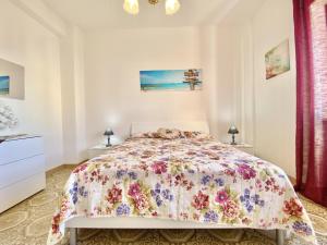 スペルロンガにあるHoliday Casaのベッドルーム1室(花柄のベッドカバー付)