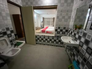 a bathroom with a sink and a toilet and a bed at Hidden Gem Residency in Kalimpong