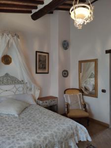 ein Schlafzimmer mit einem Bett, einem Kronleuchter und einem Stuhl in der Unterkunft Casa Crevole in Palazzina