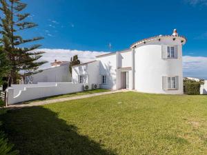 a large white house with a grass yard at Itxas Gain villa con acceso directo Calan Forcat in Cala en Forcat