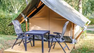 a table and two chairs in front of a tent at Safari tent XS in Berdorf