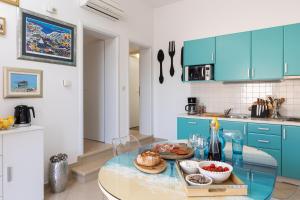 una cucina con armadi blu e un tavolo in vetro con cibo di Apartments Subrenum a Mlini