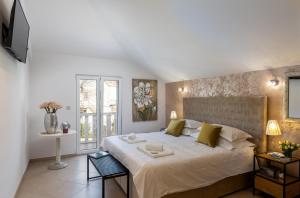 a bedroom with a large white bed and a window at Apartments Subrenum in Mlini