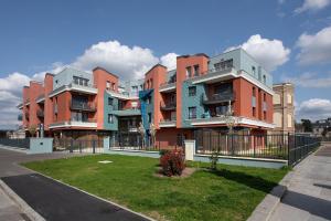 a row of apartment buildings on the side of a street at DOMITYS LA ROZE DE SEINE in Saint-Aubin-lès-Elbeuf