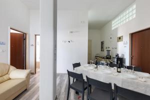 - une salle à manger avec une table, des chaises et un canapé dans l'établissement Villa Amaltea by BarbarHouse, à Casarano