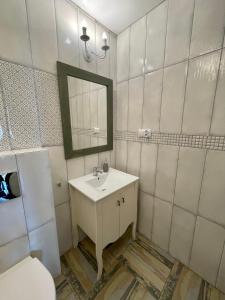 a bathroom with a sink and a mirror and a toilet at Ośrodek Promenada- Faleza in Jastrzębia Góra