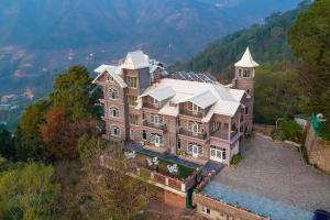 an aerial view of a large house in the mountains at StayVista at The Mansion in Kasauli