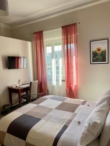 a hotel room with a bed, table, lamp and window at Villa Catelli B&B in Lucca