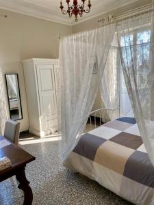 a bedroom with a bed and a window with curtains at Villa Catelli B&B in Lucca