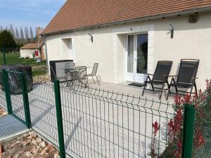 een hek voor een huis met stoelen en een tafel bij La Maison des Moutons in Romorantin