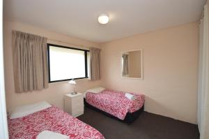 a hotel room with two beds and a window at Riverview Holiday Apartment 39 - Kalbarri WA in Kalbarri