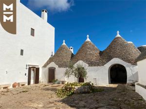 a white building with a black roof at Masseria Mangiato 1557 in Alberobello