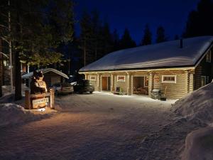 a house with a statue in front of it at night at Levillenet Bearlodge at Levi city centre in Levi