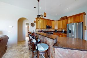 a kitchen with wooden cabinets and a counter with bar stools at Hacienda Rancho Vistoso in Oro Valley