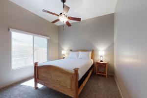 a bedroom with a bed with a ceiling fan and a window at Hacienda Rancho Vistoso in Oro Valley +40 photos