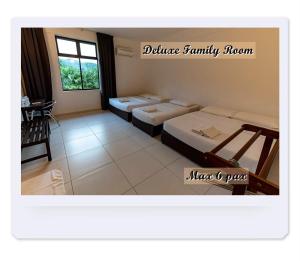 a room with four beds and a table at RIVERSIDE PALM INN SG LEMBING in Sungai Lembing