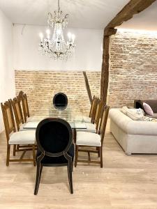 a dining room with a glass table and a chandelier at Lauramer Casco Viejo in Bilbao