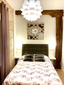Un dormitorio con una cama grande y una lámpara de araña. en Lauramer Casco Viejo, en Bilbao