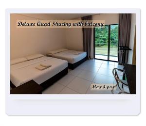 two beds in a room with a window at RIVERSIDE PALM INN SG LEMBING in Sungai Lembing