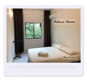 a hotel room with a bed and a window at RIVERSIDE PALM INN SG LEMBING in Sungai Lembing