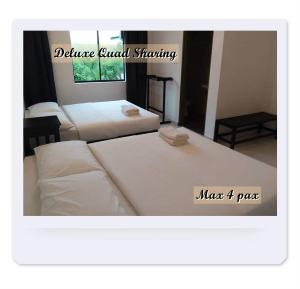 a room with two beds and a white couch at RIVERSIDE PALM INN SG LEMBING in Sungai Lembing