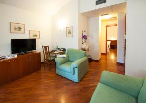 a living room with a blue chair and a television at Alla Rocca Hotel Conference & Restaurant in Bazzano Bologna