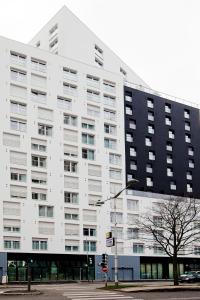 ein großes weißes Gebäude in einer Stadtstraße in der Unterkunft Séjours & Affaires Paris Bagnolet in Bagnolet